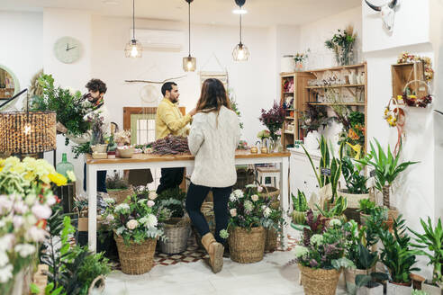 Shop owners arranging flowers standing at store - MRRF02394