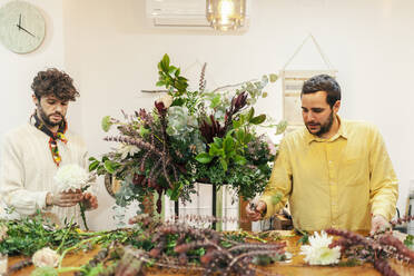 Floristen bei der Herstellung eines Blumenstraußes auf einer Werkbank im Blumenladen - MRRF02401