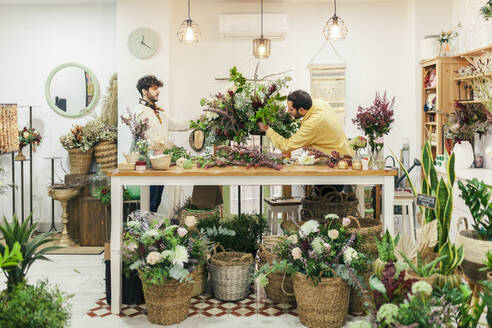 Ladenbesitzer machen Blumenstrauß auf der Werkbank im Blumenladen - MRRF02402