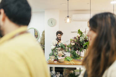 Florist macht Blumenstrauß auf Werkbank im Blumenladen - MRRF02405