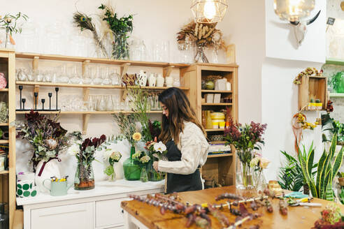 Florist hält Blume stehend im Blumenladen - MRRF02409