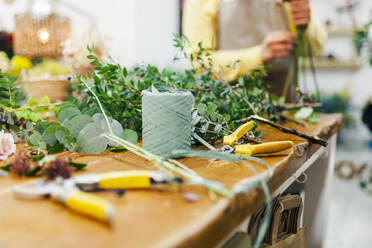 Gartengeräte nach Blättern auf der Werkbank im Blumenladen - MRRF02413