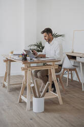 Älterer Architekt mit Smartphone und Laptop am Schreibtisch - EBBF06076