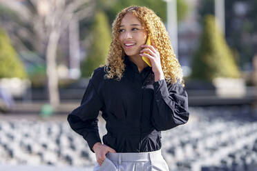 Smiling young businesswoman talking on smart phone - GGGF00963
