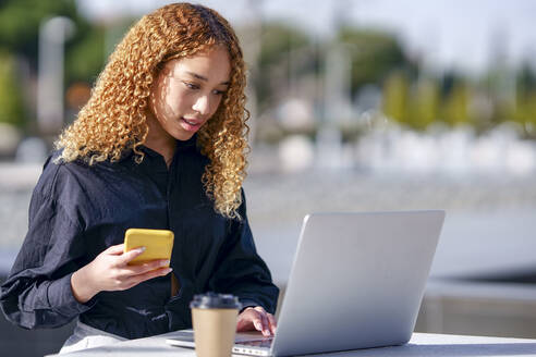 Young freelancer using laptop on sunny day - GGGF00967