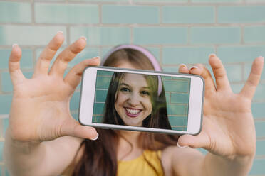 Woman taking selfie through smart phone - AMWF00563