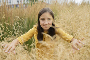 Smiling girl amidst grass in field - LESF00001