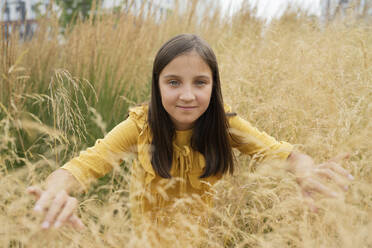 Smiling pre-adolescent girl amidst grass in field - LESF00002