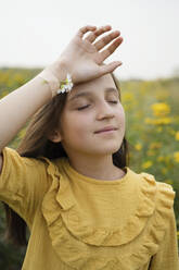 Girl with chamomiles attached on hand with bandage in field - LESF00019