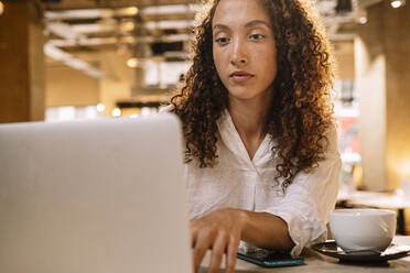 Entschlossene Geschäftsfrau mit Laptop im Büro - AMWF00591