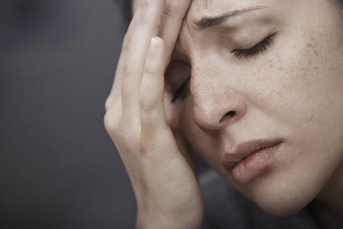 Traurige Frau leidet unter Kopfschmerzen - AZF00430