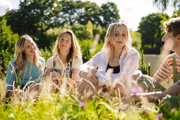 Glückliche Freunde verbringen Zeit zusammen im Park an einem sonnigen Tag - AMWF00627