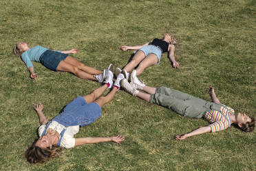 Freunde liegen zusammen im Gras im Park - AMWF00653