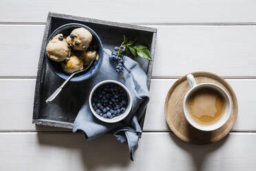 Tasse Kaffee und Tablett mit frischen Heidelbeeren und hausgemachtem Erdnusseis - EVGF04077