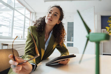 Businesswoman with tablet PC sitting at desk in office - JOSEF12948