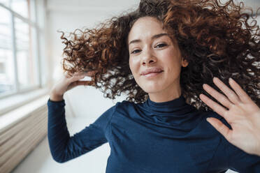 Smiling young woman tossing hair - JOSEF12967