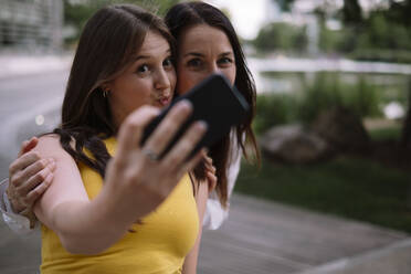 Frauen machen Selfie mit Handy im Park - AMWF00737