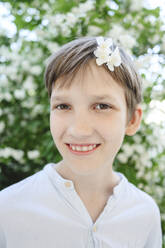 Glücklicher Junge mit Jasminblüte im Haar - EYAF02151
