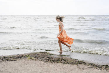 Mädchen spaziert am Meer am Strand - EYAF02154