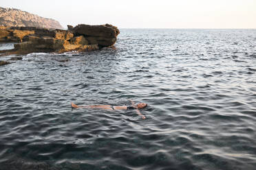 Frau schwimmt auf dem Wasser im Meer - MMPF00268