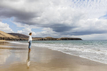 Junge Frau mit Blick auf das Meer an einem sonnigen Tag - MRAF00905