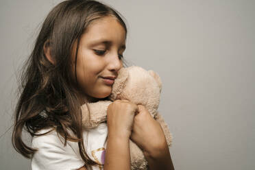 Lächelndes Mädchen umarmt Teddybär - EGAF02567
