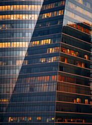 Low Winkel der modernen geometrischen hohen Bürogebäude bei Nacht mit dichten verspiegelte Fenster mit Licht auf - ADSF36421