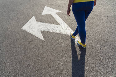 Woman standing on arrow symbol - OSF00802