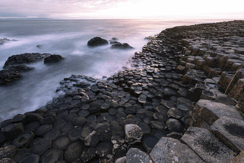 Wellen, die gegen Basaltsteine am Giant's Causeway, Nordirland, rauschen - FCF02060