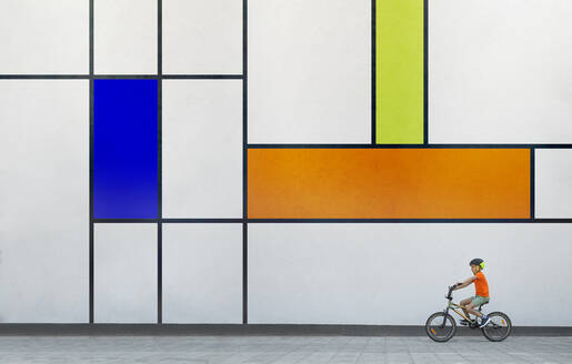 Boy riding BMX bike by colorful patterned wall - ZEDF04766