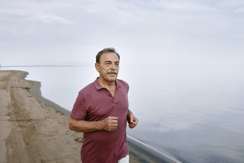Älterer Mann läuft am Strand - AZF00466