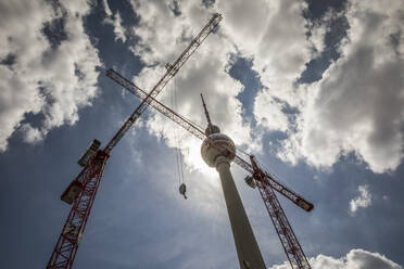 Cranes near Berlin Television Tower under cloudy sky at Alexanderplatz, Berlin, Germany - JMF00631