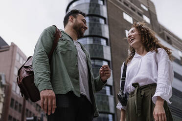 Cheerful couple standing together in front of building - AMWF00778