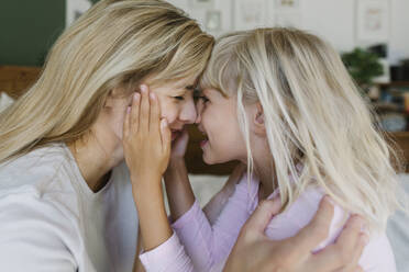 Glückliche Mutter und Tochter kuscheln zu Hause mit den Nasen - TYF00396