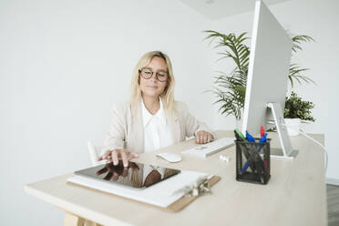 Geschäftsfrau mit Tablet-PC am Schreibtisch im Büro - EBBF06155