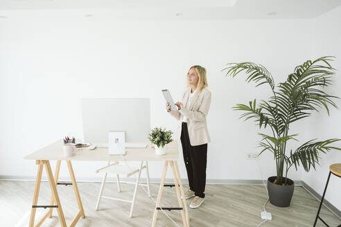 Geschäftsfrau im Büro stehend mit Tablet-PC - EBBF06170