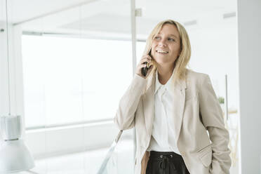 Lächelnde Geschäftsfrau am Telefon im Büro - EBBF06222