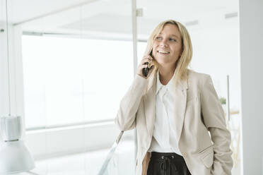 Smiling businesswoman on the phone in office - EBBF06222