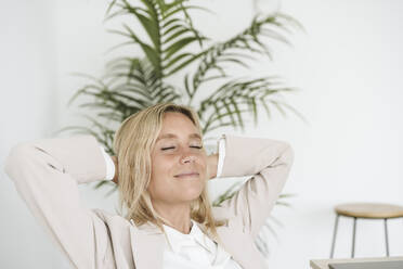 Entspannte Geschäftsfrau mit geschlossenen Augen im Büro - EBBF06247