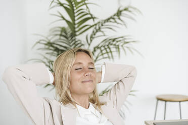 Relaxed businesswoman with closed eyes in office - EBBF06247