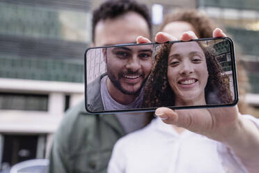 Lächelnde Freunde machen ein Selfie mit ihrem Smartphone - AMWF00793