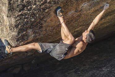 Determined athlete doing rock climbing on sunny day - GGGF01095