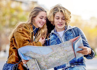 Junge Touristen schauen im Urlaub auf die Karte - GGGF01104