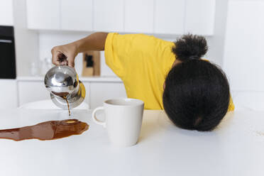 Exkausted woman spilling coffee on kitchen table - SIF00482