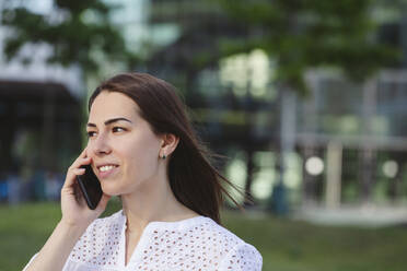Lächelnde Geschäftsfrau, die ein Mobiltelefon aufnimmt - IHF01171
