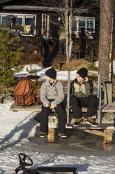 Jungen in voller Länge auf dem Steg sitzend an einem sonnigen Tag - MASF31446