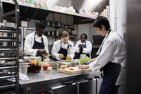 Multirassische Köche arbeiten in der Großküche eines Restaurants - MASF31542