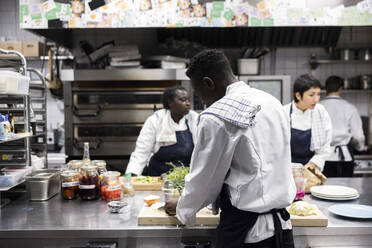 Multirassische Köche bei der Zubereitung von Speisen in der Küche eines Restaurants - MASF31565