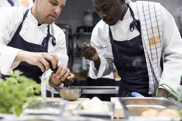 Männliche Köche bei der Zubereitung von Speisen in der Küche eines Restaurants - MASF31570