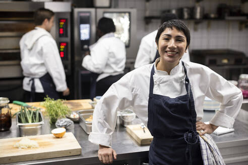 Porträt einer lächelnden Köchin in einer Großküche eines Restaurants - MASF31619